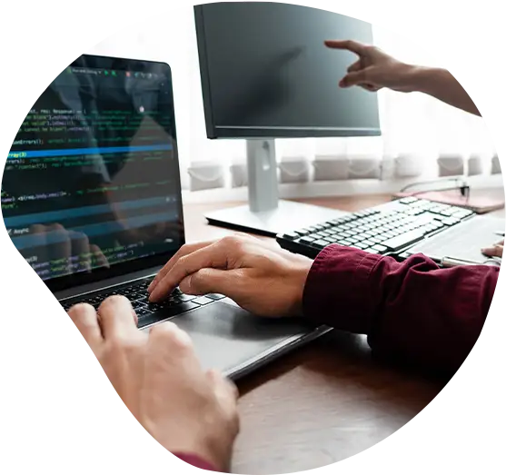 Zwei Developer besprechen ein Projekt vor ihren Monitoren