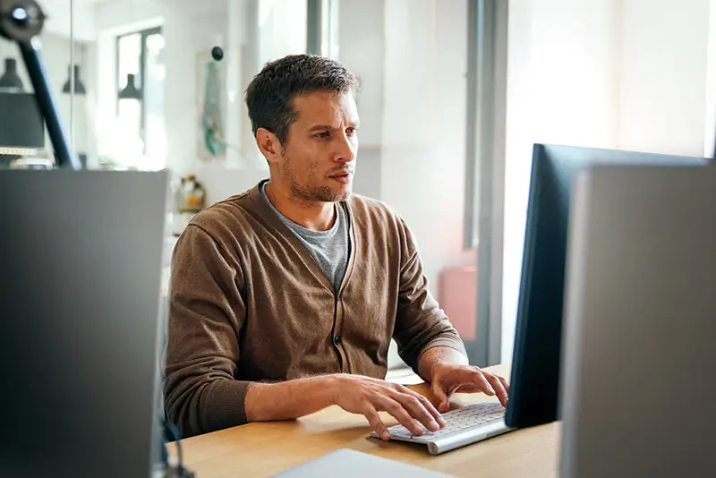 Ein junger Mann sitzt vor seinem Computer