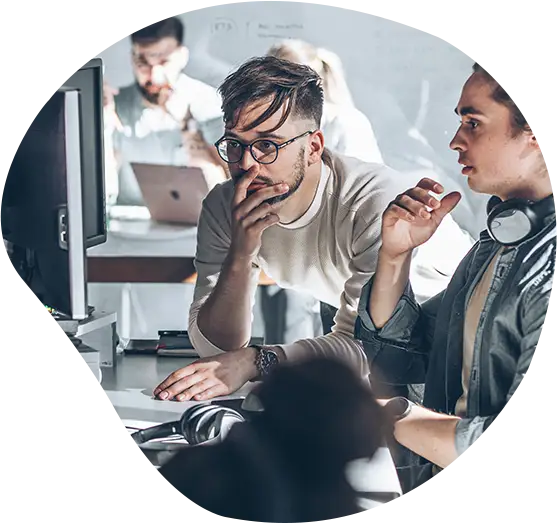 Mehrere Mitglieder eines Projektteams diskutieren ein Projekt vor ihren Bildschirmen