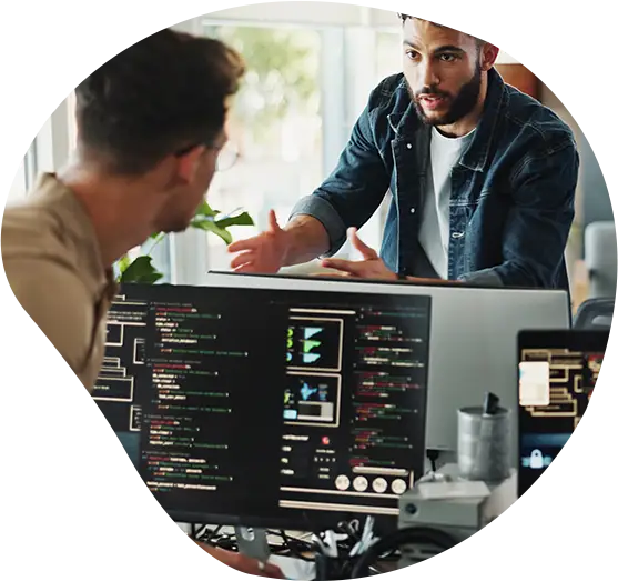 Teambesprechung von Software Developern über Monitore hinweg