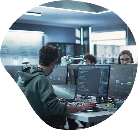 Mehrere Personen arbeiten an Bildschirmen in einem Großraumbüro