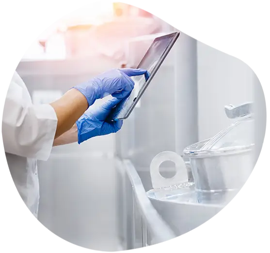 Eine Person im Laborkittel mit Tablet bei Prüfung der Produktion mit KI-Software