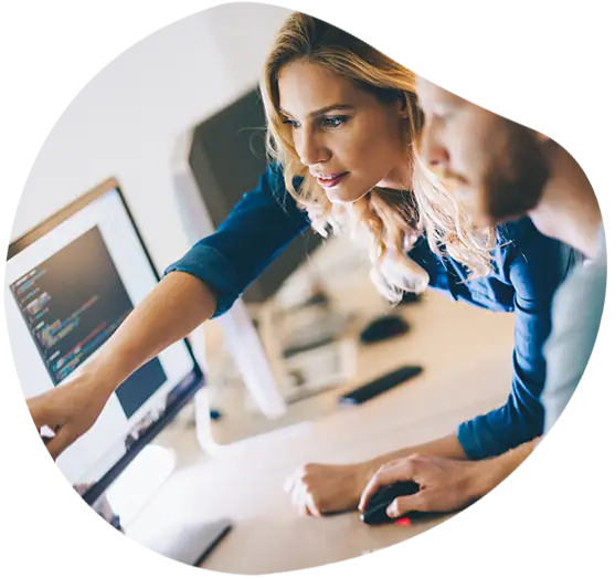 Zwei Kolleg*Innen beraten sich über Bildschirmen