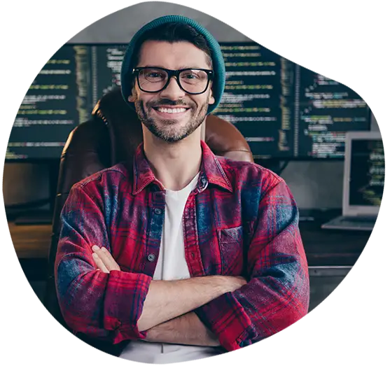 Ein freundlicher Developer lächelt vor seinem Arbeitsplatz einladend in die Kamera