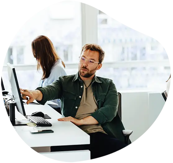 Ein Developer zeigt etwas auf seinem Bildschirm