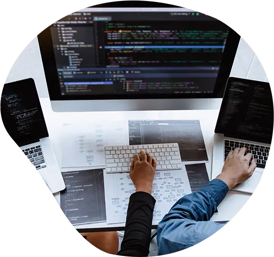 Zwei Programmierer sitzen vor ihren Monitoren und besprechen ein Software-Projekt
