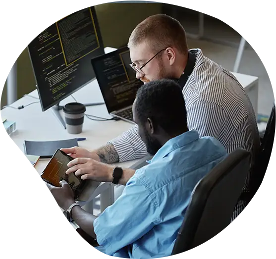 Zwei Softwareentwickler besprechen ein Projekt an einem Schreibtisch.