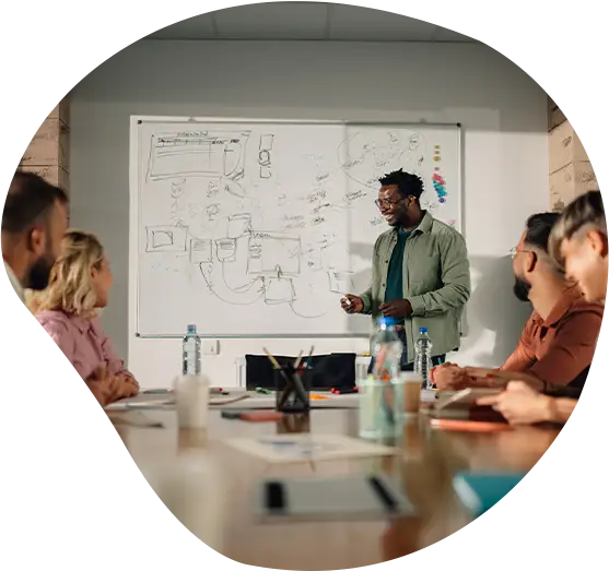 Projektmanager präsentiert Kollegen ein neues Projekt im Besprechungsraum.