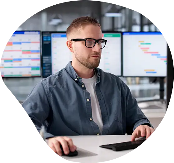 Ein Softwareentwickler sitzt an seinem Arbeitsplatz vor einem Bildschirm.