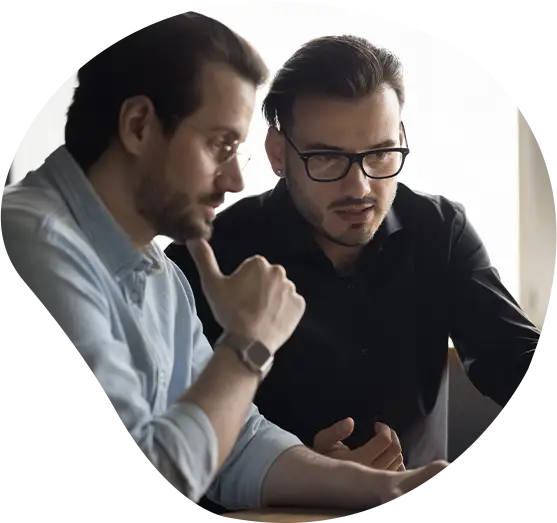 Konzentrierte, engagierte Softwareentwickler besprechen eine Online-Anwendung, schauen auf den Bildschirm, betrachten Internetinhalte und zeigen mit besorgtem Blick auf den Laptop-Bildschirm.