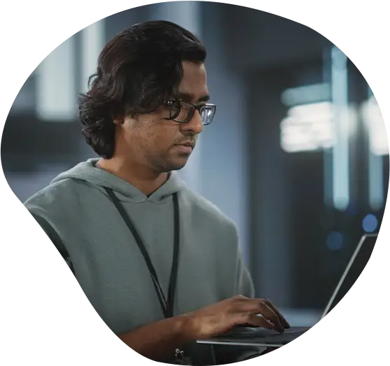 Porträt eines Managers einer technologischen Softwareentwicklungsabteilung, der steht und einen Laptop benutzt.