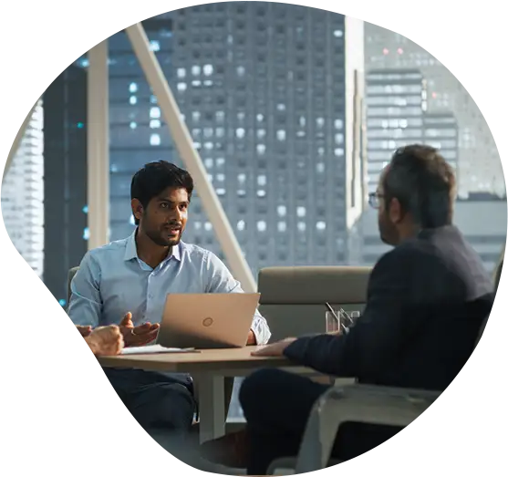 2 Männer führen ein Gespräch in einem Besprechungsraum.