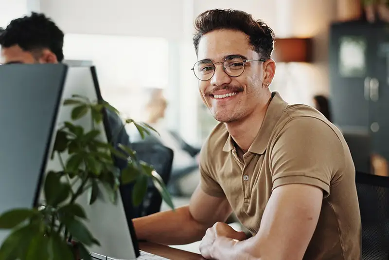 Ein freundlicher Programmierer lächelt in die Kamera