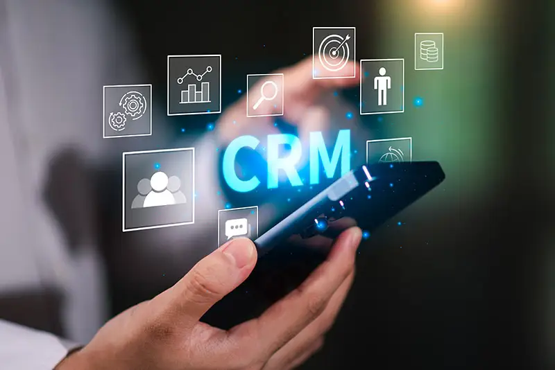 "CRM-Software" schwebt über einem Smartphone