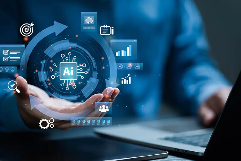 Über einer hand schweben Icons - in der Mitte das Icon für KI "AI"