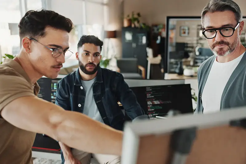 Zwei Developer und ein Projektmanager besprechen ein Projekt