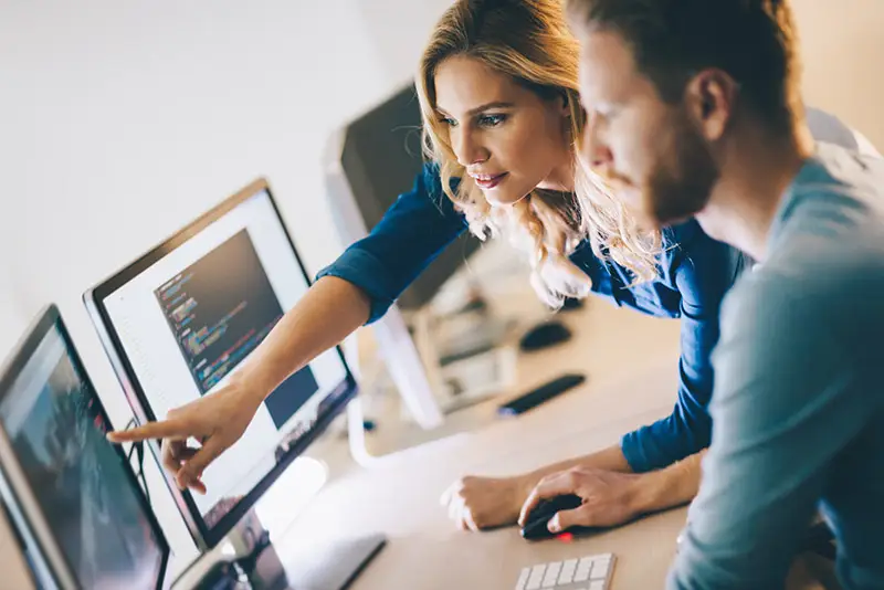 Eine Angestellte deutet auf einen Bildschirm