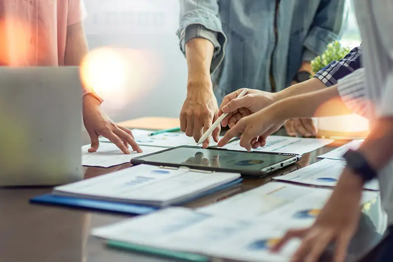 Ein Software Development-Team bei der Besprechung über Tablet und Papieren