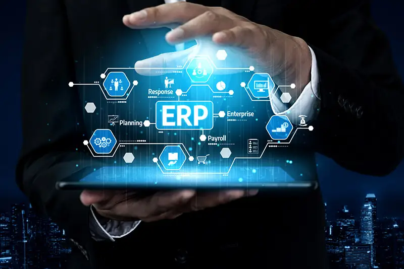 "ERP" schebt über einem Tablet welches von einem Geschäftsmann gehalten wird