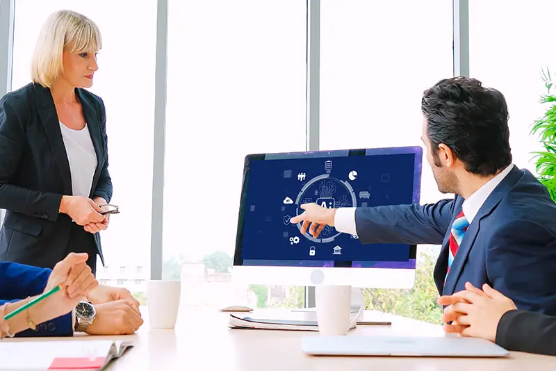 Ein Manager in einer Konferenz deutet auf einen Monitor