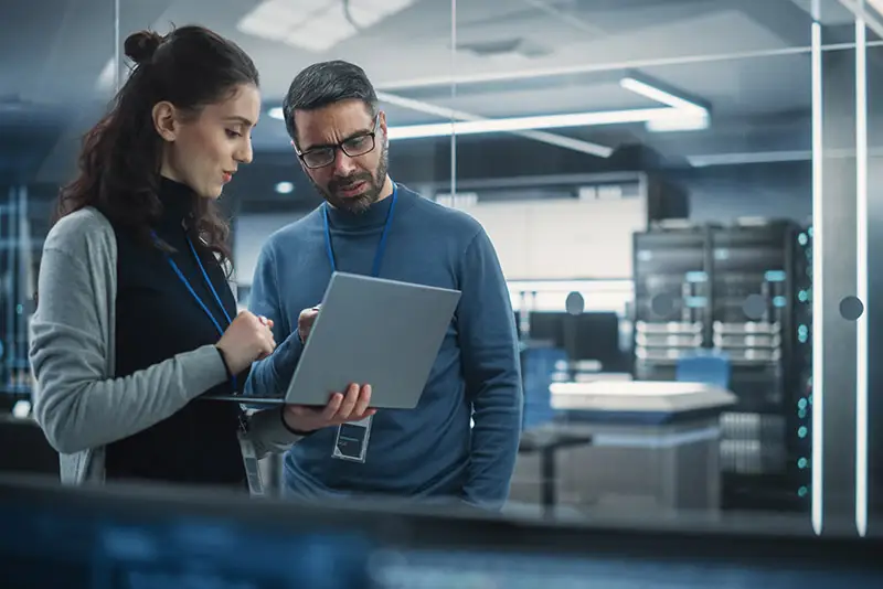 Zwei Kolleg*innen betrachten ein Tablet