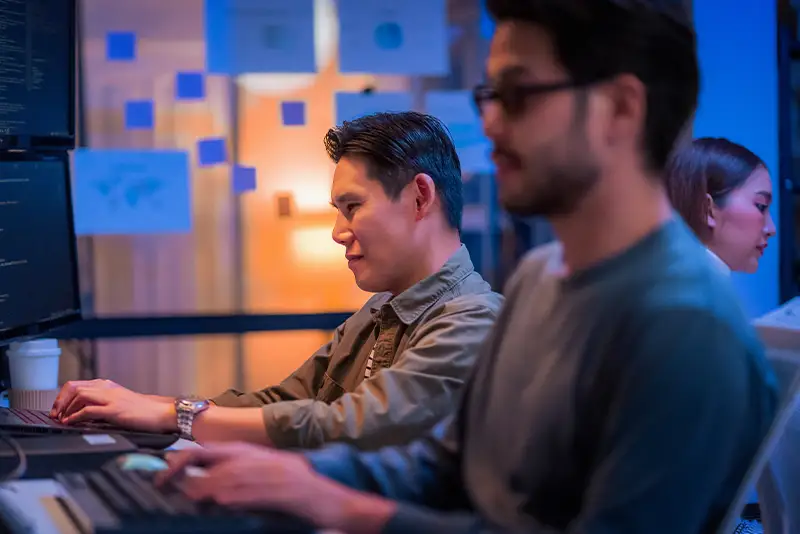 Softwareentwicklungsmanager leitet eine Bürobesprechung mit seinem Führungsteam, betreut Entwickler und analysiert Quellcode, um die Programmierung und Projektentwicklung zu steuern.