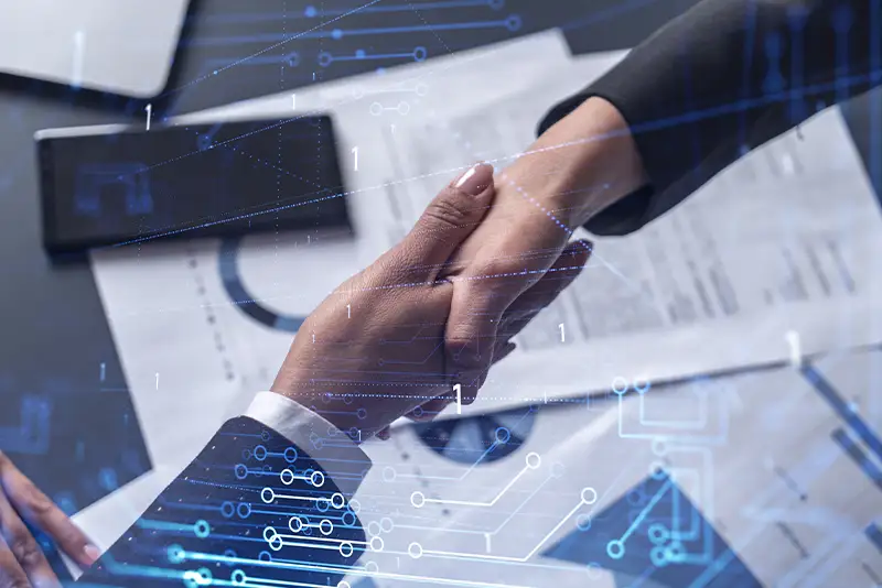 Handschlag zweier Personen, die einen Vertrag zur Entwicklung neuer Software abschließen.