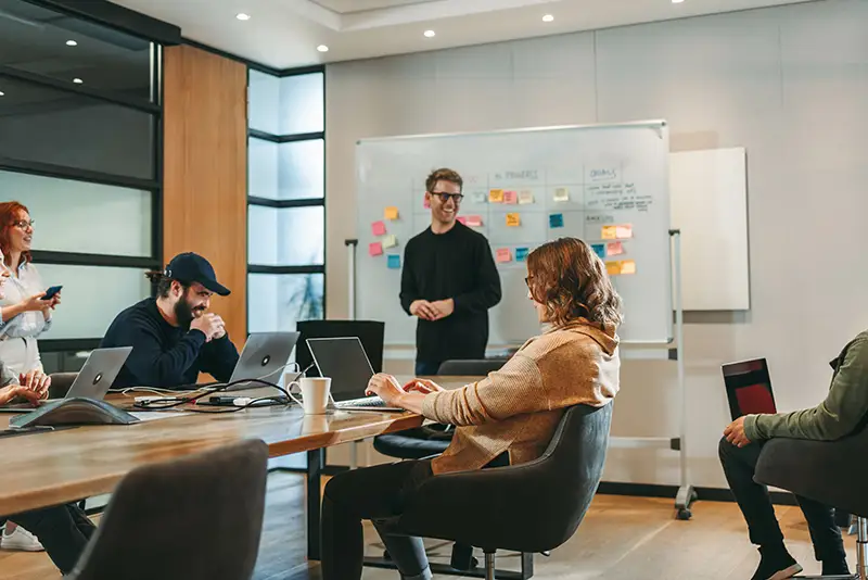 Mehrere Mitarbeiter sitzen in einem Konferenzraum und besprechen Ihr Projekt.